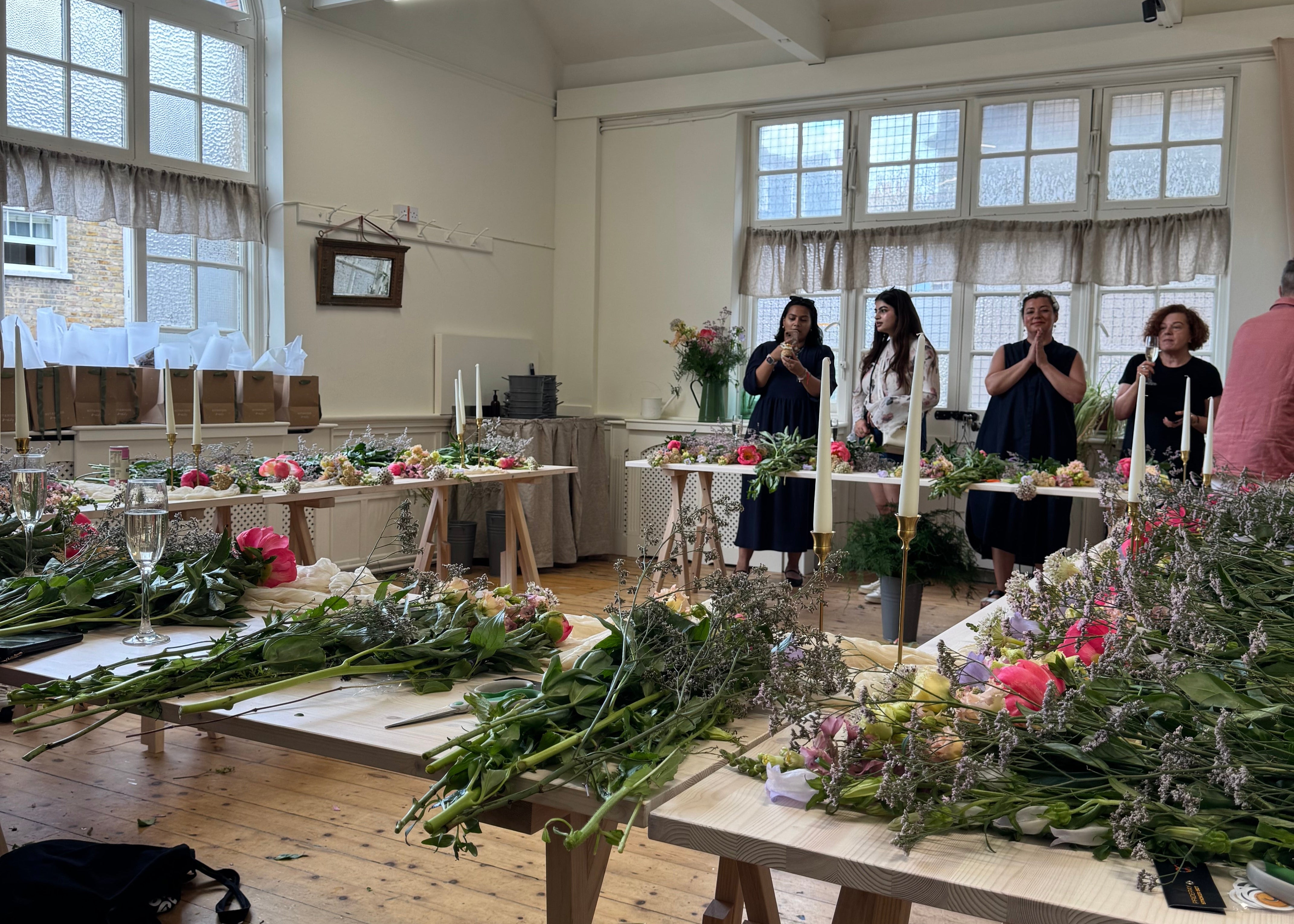 4 women at a group flower workshop with botanique workshop in london, with flowers ready to create a bouquet.